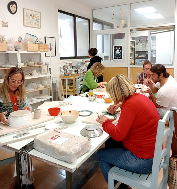 Clase-Adultos-03 grupo de personas en clase de cerámica esmaltando piezas en un taller