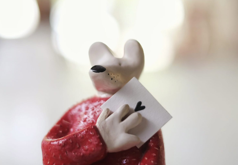Home-HeyJuddy---Raton-carta-de-amor Figura cerámica de un ratón con un jersey rojo sosteniendo una carta con un corazon